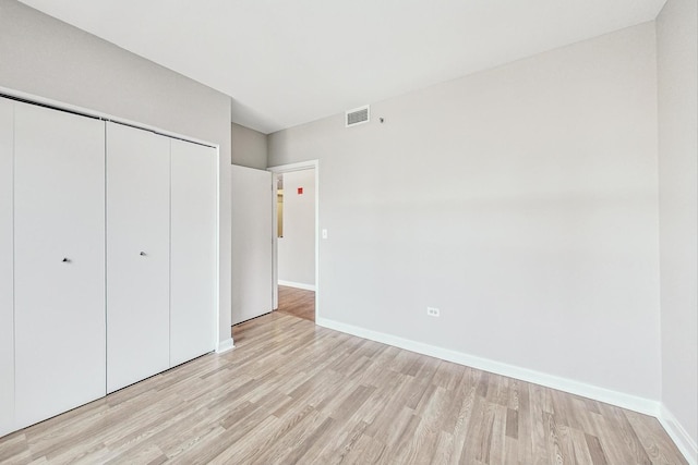 unfurnished bedroom featuring a closet and light hardwood / wood-style flooring