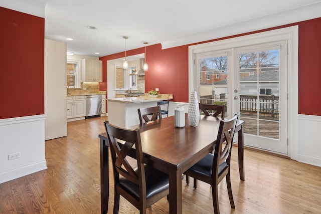 dining area featuring recessed lighting, light wood-style floors, and wainscoting