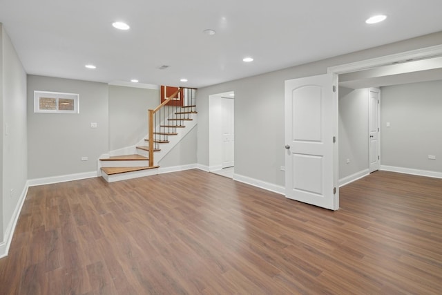 finished basement with stairs, wood finished floors, recessed lighting, and baseboards