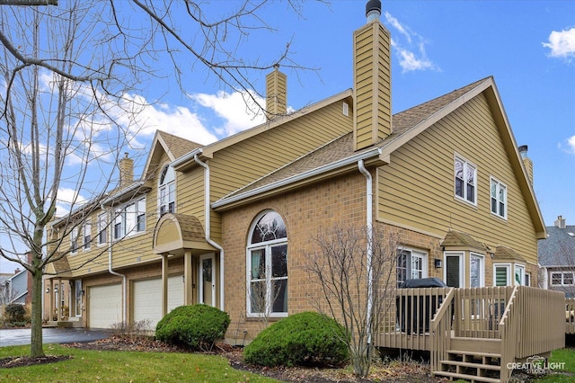 view of side of property featuring a garage and a wooden deck