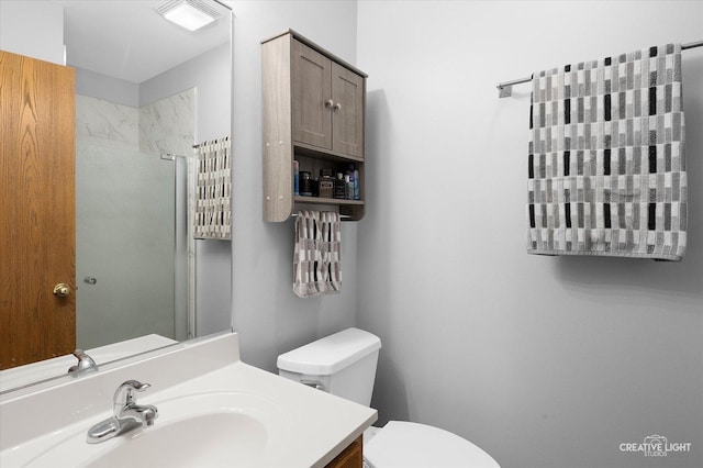 bathroom with an enclosed shower, vanity, and toilet