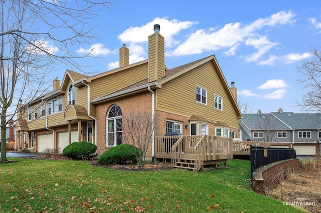 back of house with a garage, a yard, and a wooden deck