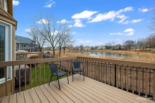 deck with a lawn and a water view