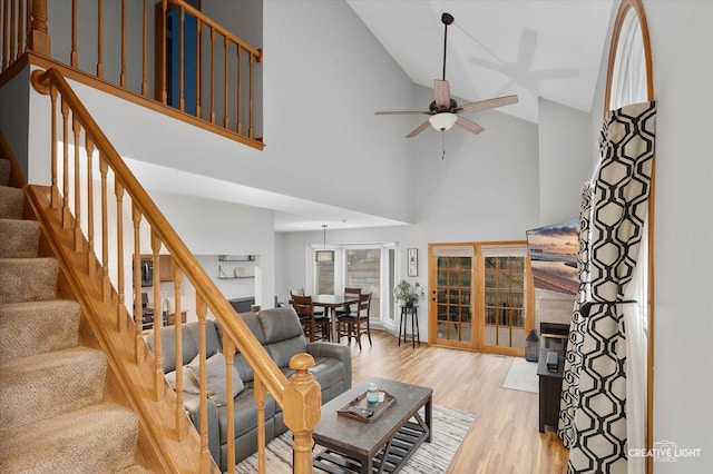 unfurnished living room featuring ceiling fan, light hardwood / wood-style flooring, and high vaulted ceiling