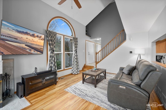 living room featuring high vaulted ceiling, light hardwood / wood-style flooring, and ceiling fan