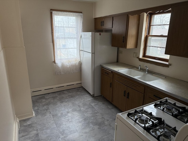 kitchen with sink, white appliances, and a baseboard heating unit