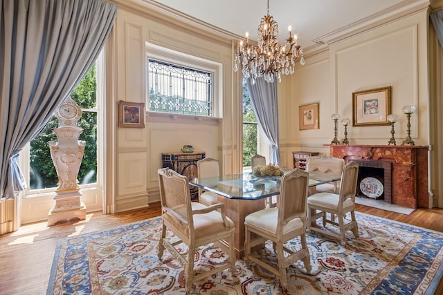 dining space featuring light hardwood / wood-style floors, a high ceiling, ornamental molding, and a notable chandelier