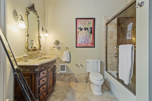 full bathroom with bath / shower combo with glass door, toilet, and vanity