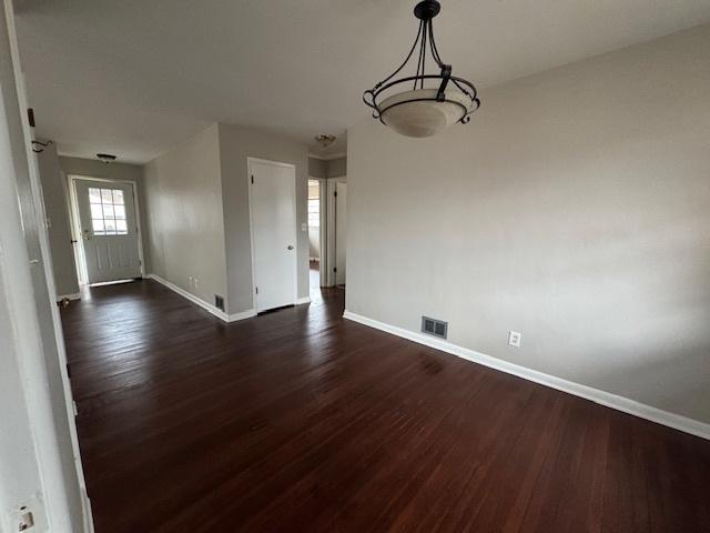 unfurnished dining area with dark wood-type flooring