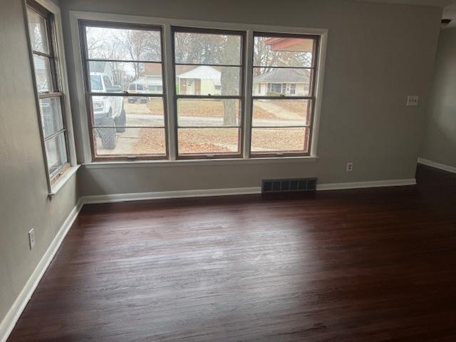 unfurnished room with dark wood-type flooring