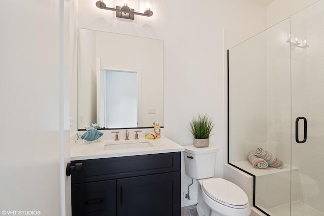 full bath with a stall shower, vanity, and toilet