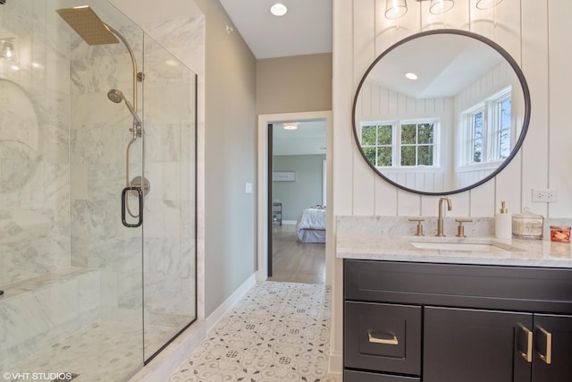 ensuite bathroom featuring baseboards, ensuite bathroom, a tile shower, vanity, and recessed lighting