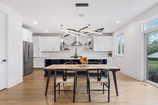 dining space with light wood finished floors, baseboards, and recessed lighting