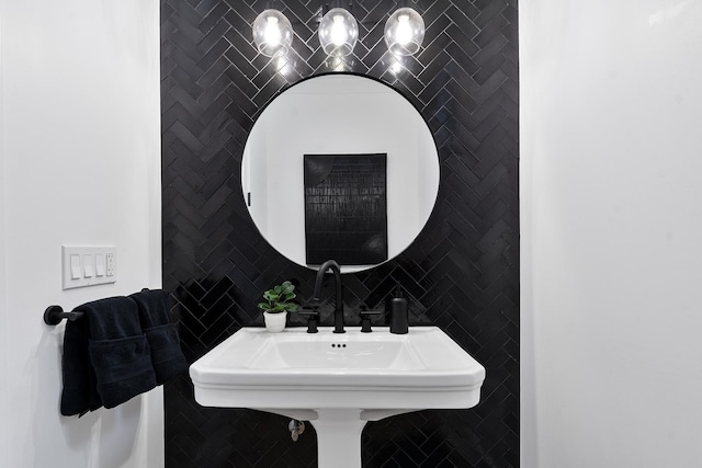 bathroom featuring a sink and tile walls