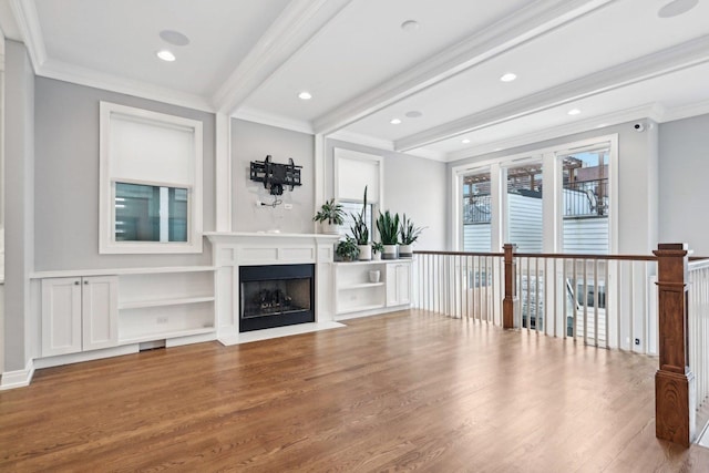 unfurnished living room with beam ceiling, crown molding, and hardwood / wood-style floors