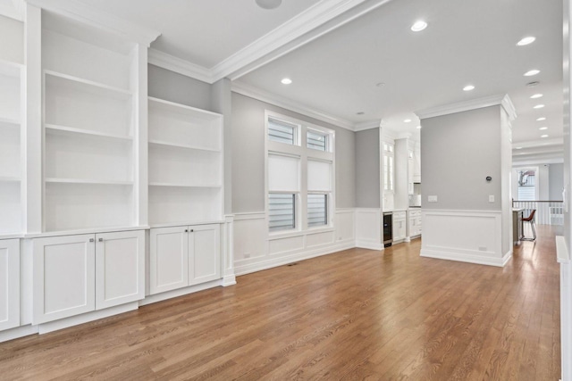 unfurnished living room with crown molding and light hardwood / wood-style floors