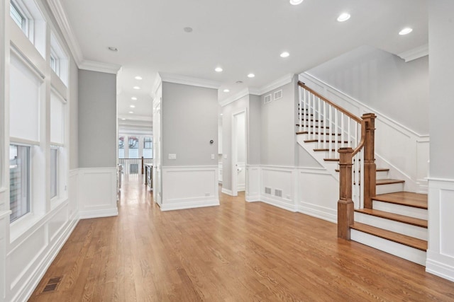 unfurnished living room with light hardwood / wood-style floors and ornamental molding