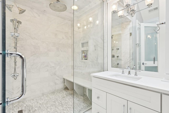 bathroom featuring vanity and a shower with door