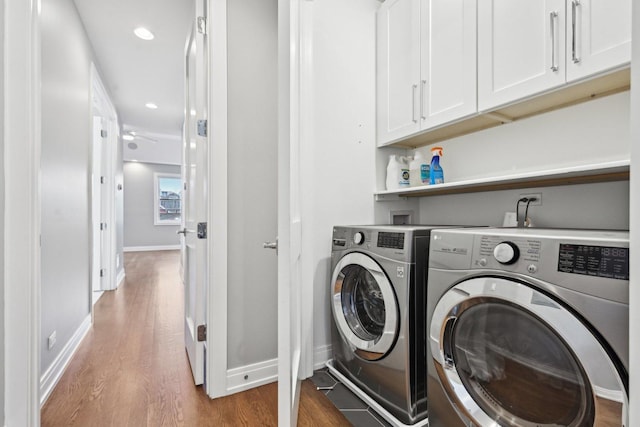 laundry room with washing machine and dryer, ceiling fan, cabinets, and hardwood / wood-style flooring