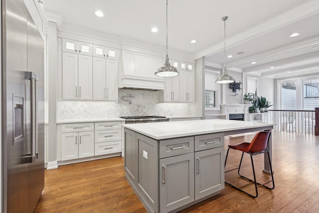 kitchen with white cabinetry, a center island, light wood-type flooring, and appliances with stainless steel finishes