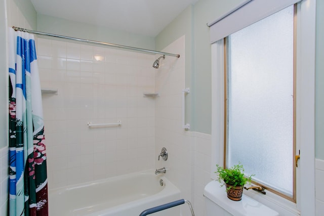 bathroom with shower / bathtub combination with curtain and toilet