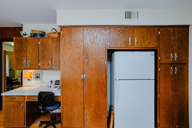 kitchen with white refrigerator and built in desk