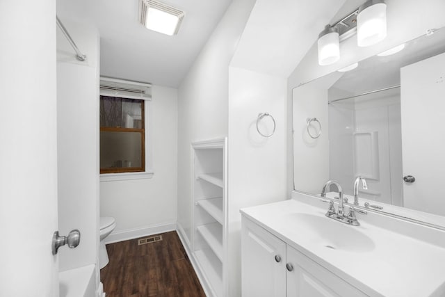 bathroom with vanity, a shower, lofted ceiling, hardwood / wood-style flooring, and toilet