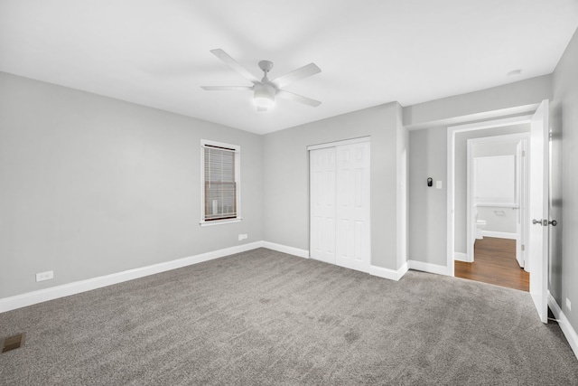 unfurnished bedroom featuring a closet, dark carpet, and ceiling fan