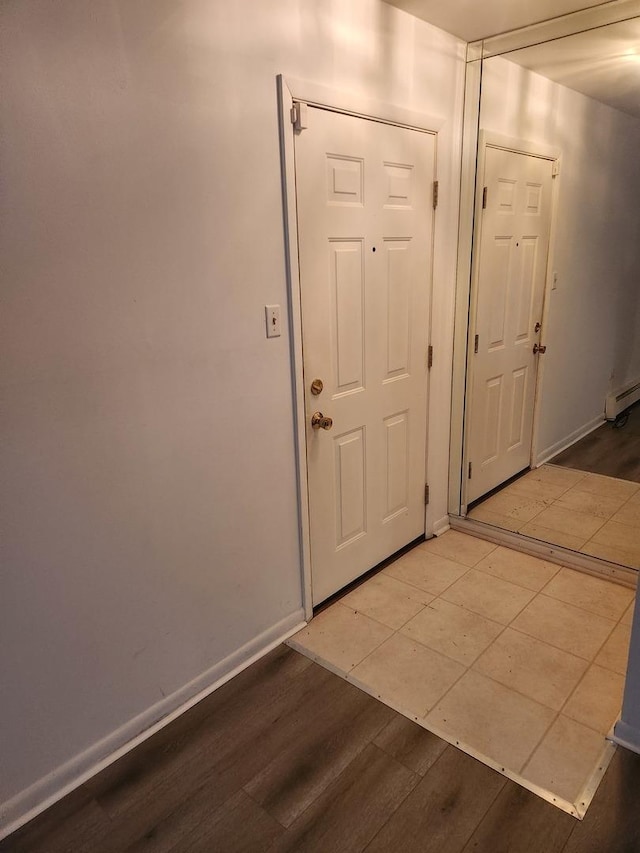 doorway with a baseboard heating unit and hardwood / wood-style flooring