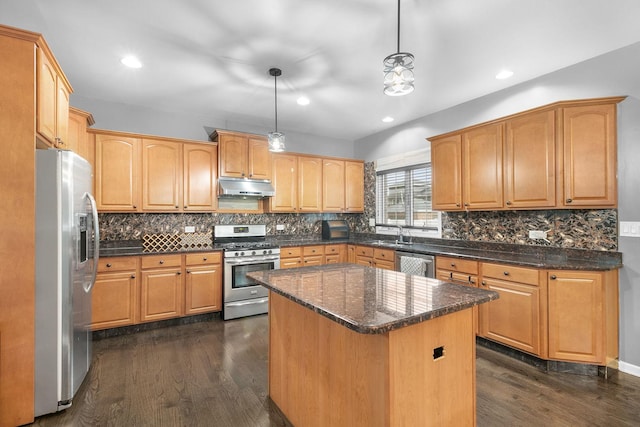 kitchen featuring a center island, hanging light fixtures, dark hardwood / wood-style floors, tasteful backsplash, and stainless steel appliances