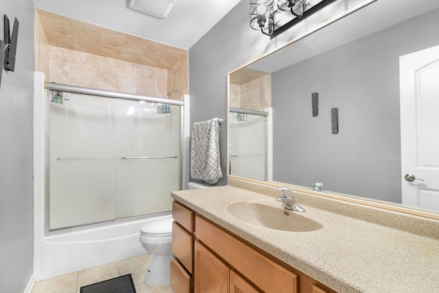 full bathroom featuring shower / bath combination with glass door, vanity, tile patterned floors, and toilet