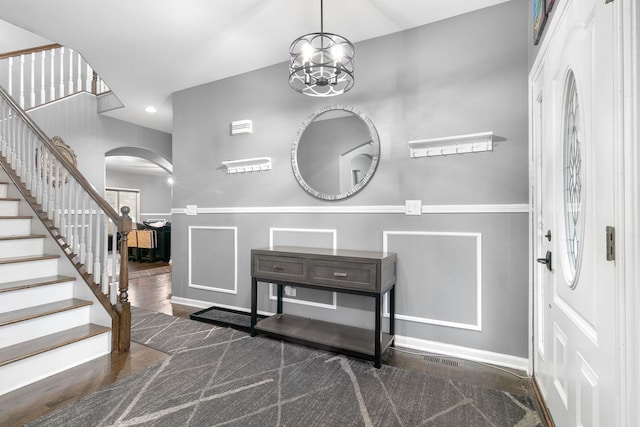 foyer entrance featuring dark hardwood / wood-style floors and a notable chandelier