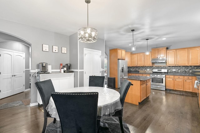 dining area featuring dark wood-type flooring and a notable chandelier