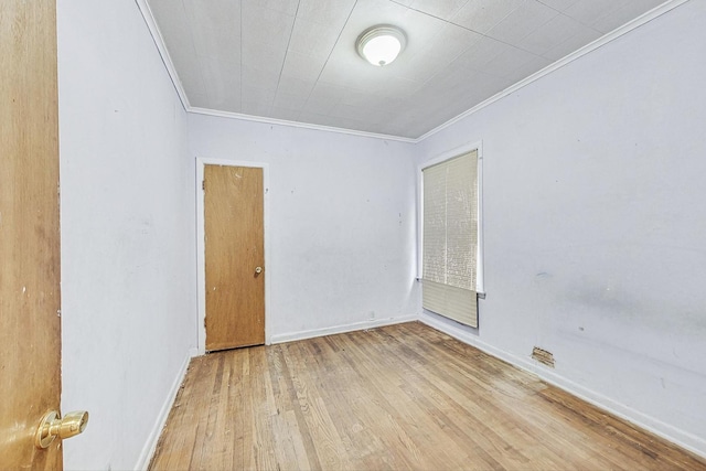 empty room with light hardwood / wood-style floors and ornamental molding