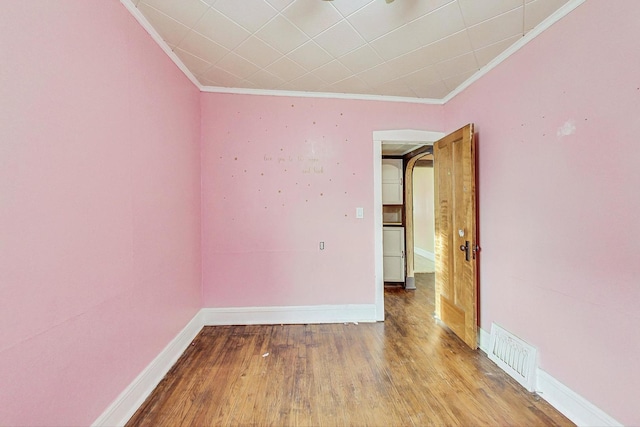 unfurnished room with hardwood / wood-style floors and crown molding