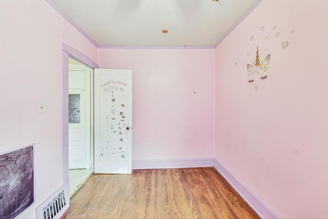 empty room featuring light hardwood / wood-style flooring and ornamental molding