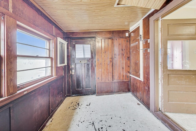 doorway to outside with wooden walls