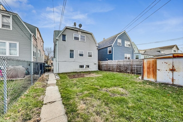 rear view of house featuring a yard and a storage shed