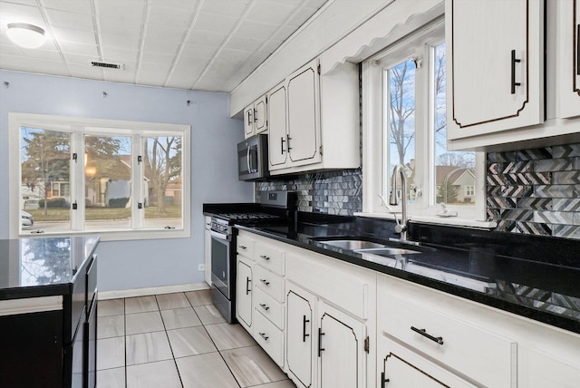 kitchen featuring a healthy amount of sunlight, white cabinetry, sink, and stainless steel appliances