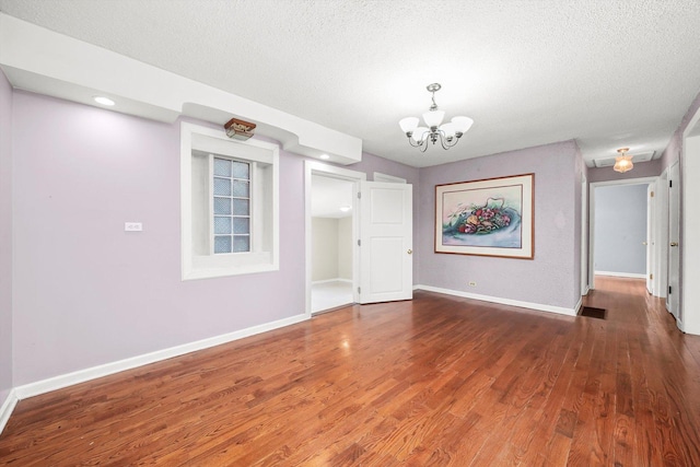 interior space featuring dark hardwood / wood-style floors, a textured ceiling, and a chandelier