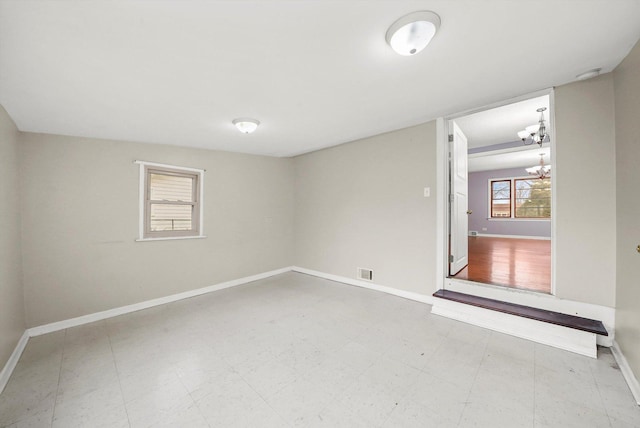 spare room featuring a notable chandelier