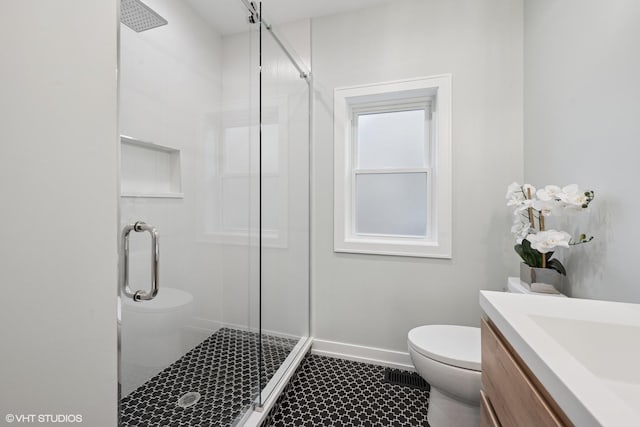 bathroom with tile patterned flooring, baseboards, a shower stall, and toilet