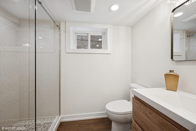 full bathroom featuring toilet, vanity, wood finished floors, tiled shower, and baseboards