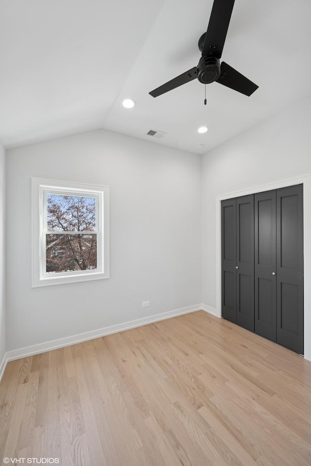 unfurnished bedroom featuring lofted ceiling, light wood finished floors, recessed lighting, and baseboards