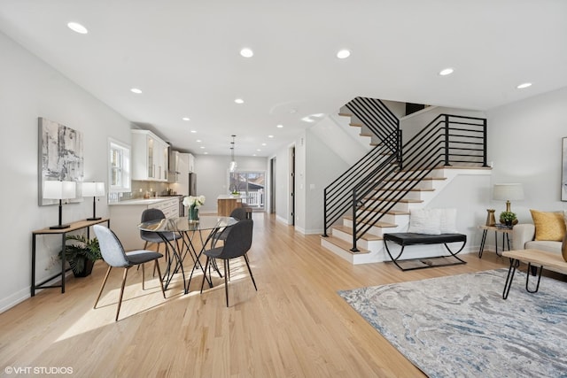 dining area with baseboards, stairway, recessed lighting, and light wood-style floors