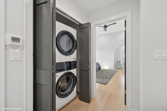 laundry room with stacked washer / dryer, laundry area, and light wood-style flooring