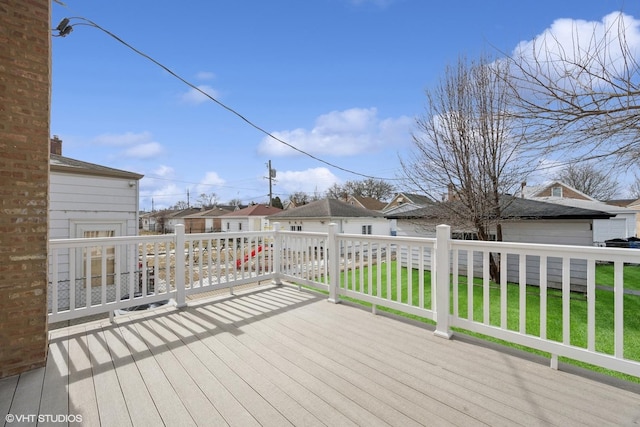 wooden terrace featuring a residential view and a yard