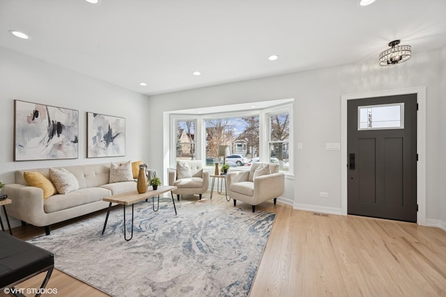 living area featuring recessed lighting, light wood-style flooring, and baseboards