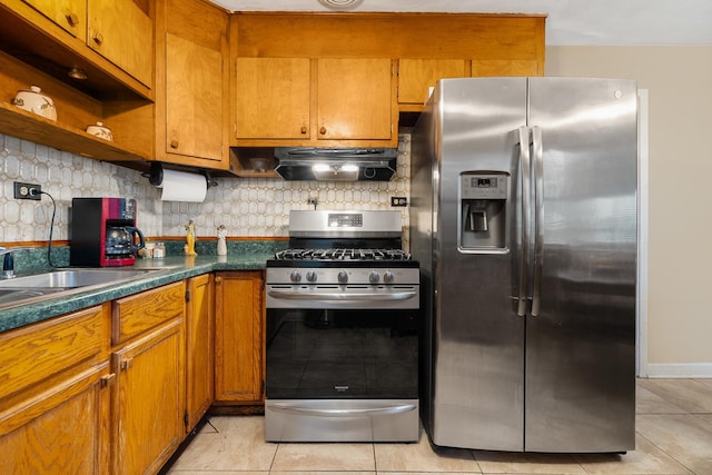 kitchen with sink, light tile patterned floors, backsplash, and appliances with stainless steel finishes