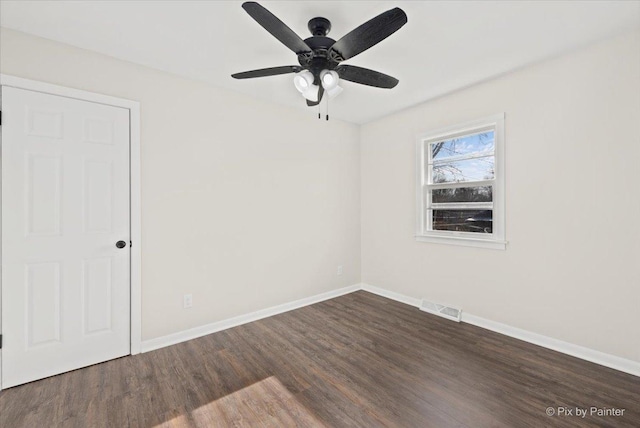 spare room featuring ceiling fan and dark wood-type flooring